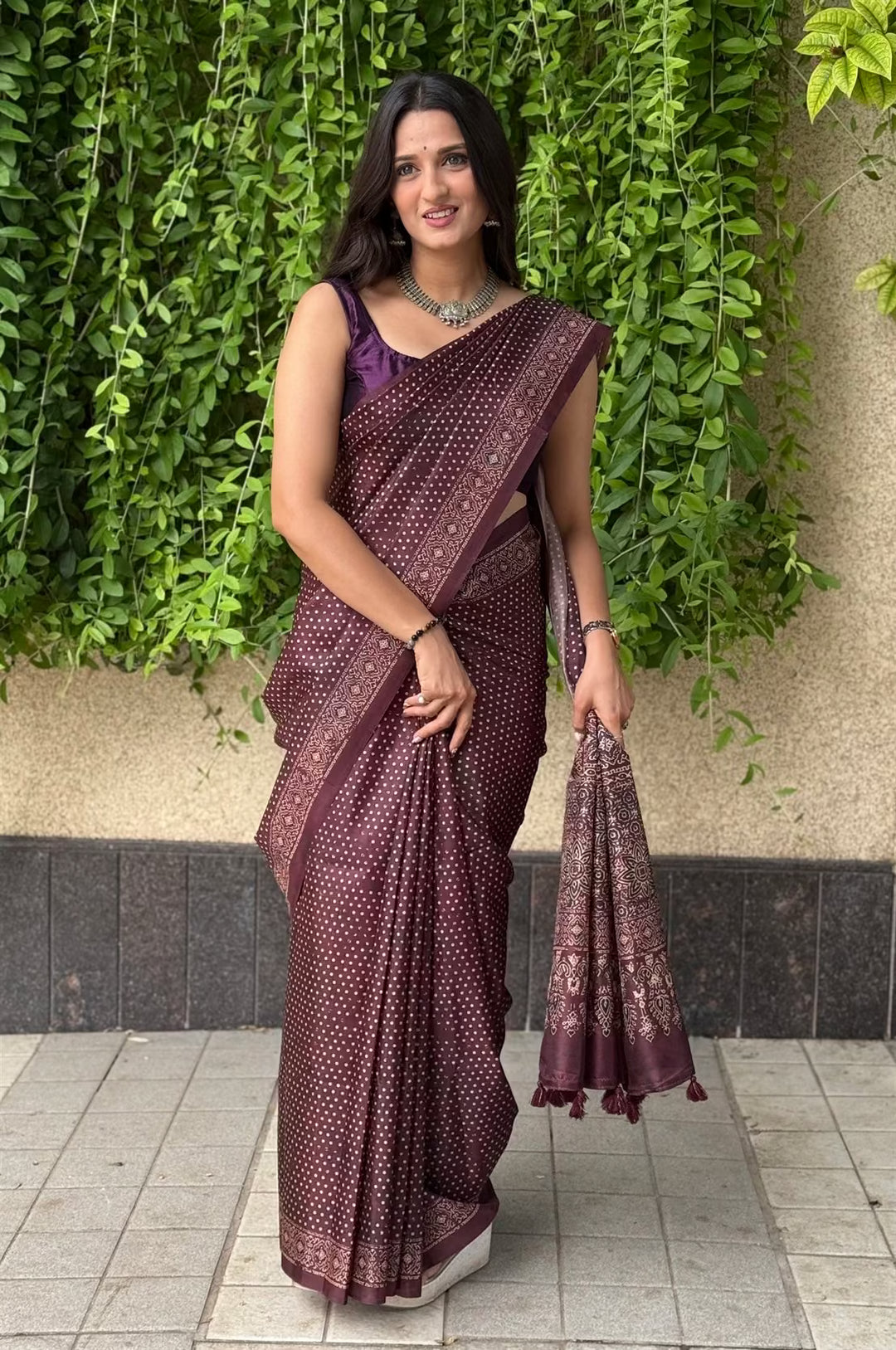 Woman wearing a Polka Dot Dark Maroon with Ajrakh pallu saree.