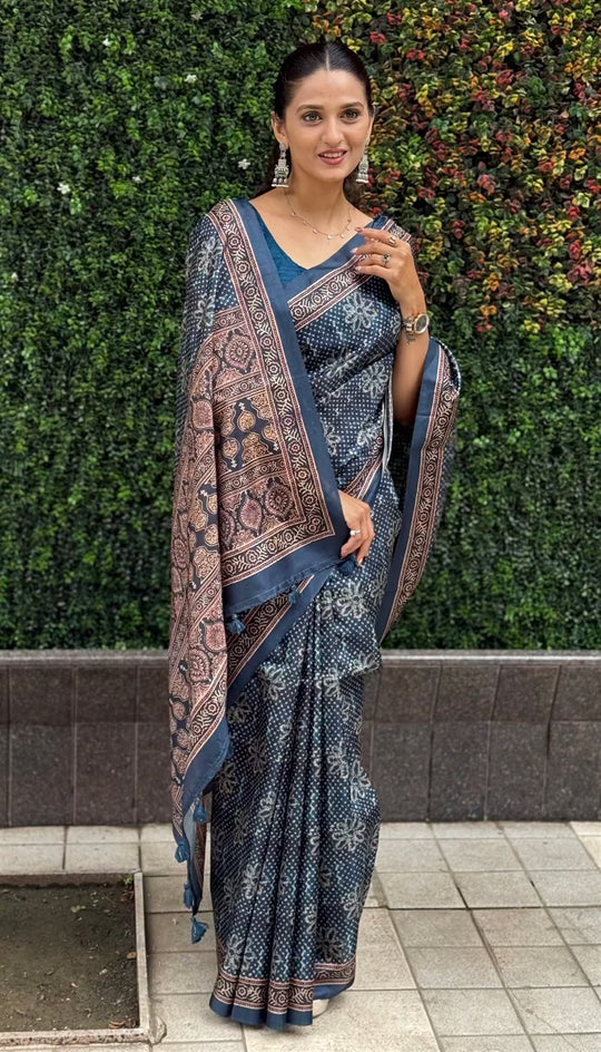 Woman wearing a Ajrakh Pallu Border With Dot & Floral Butti Tussar silk saree.