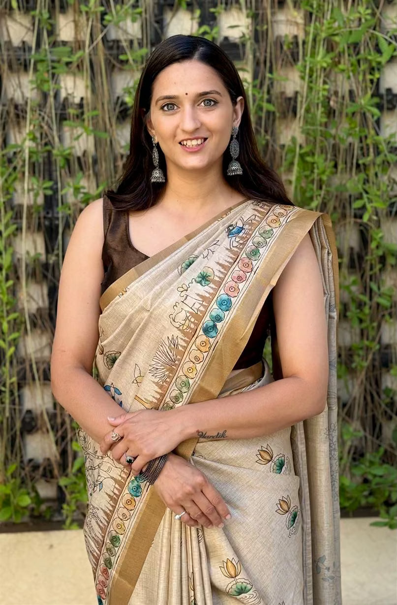 Woman wearing Cream Gold Saree in Kalamkari Print.