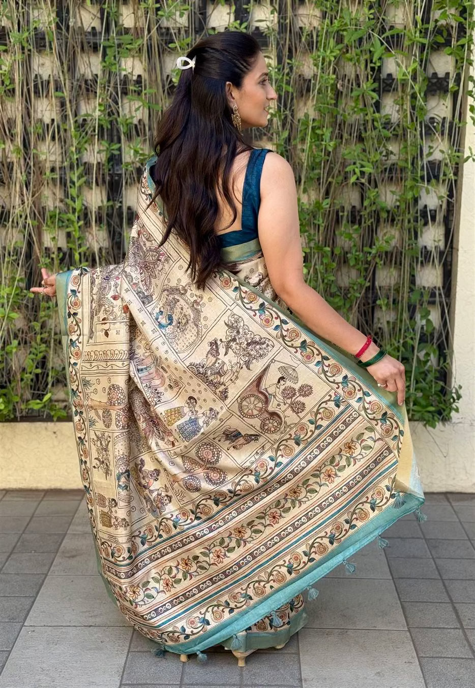 Woman in traditional Kalamkari print saree With Zari Border in Soft Silk Fabric.