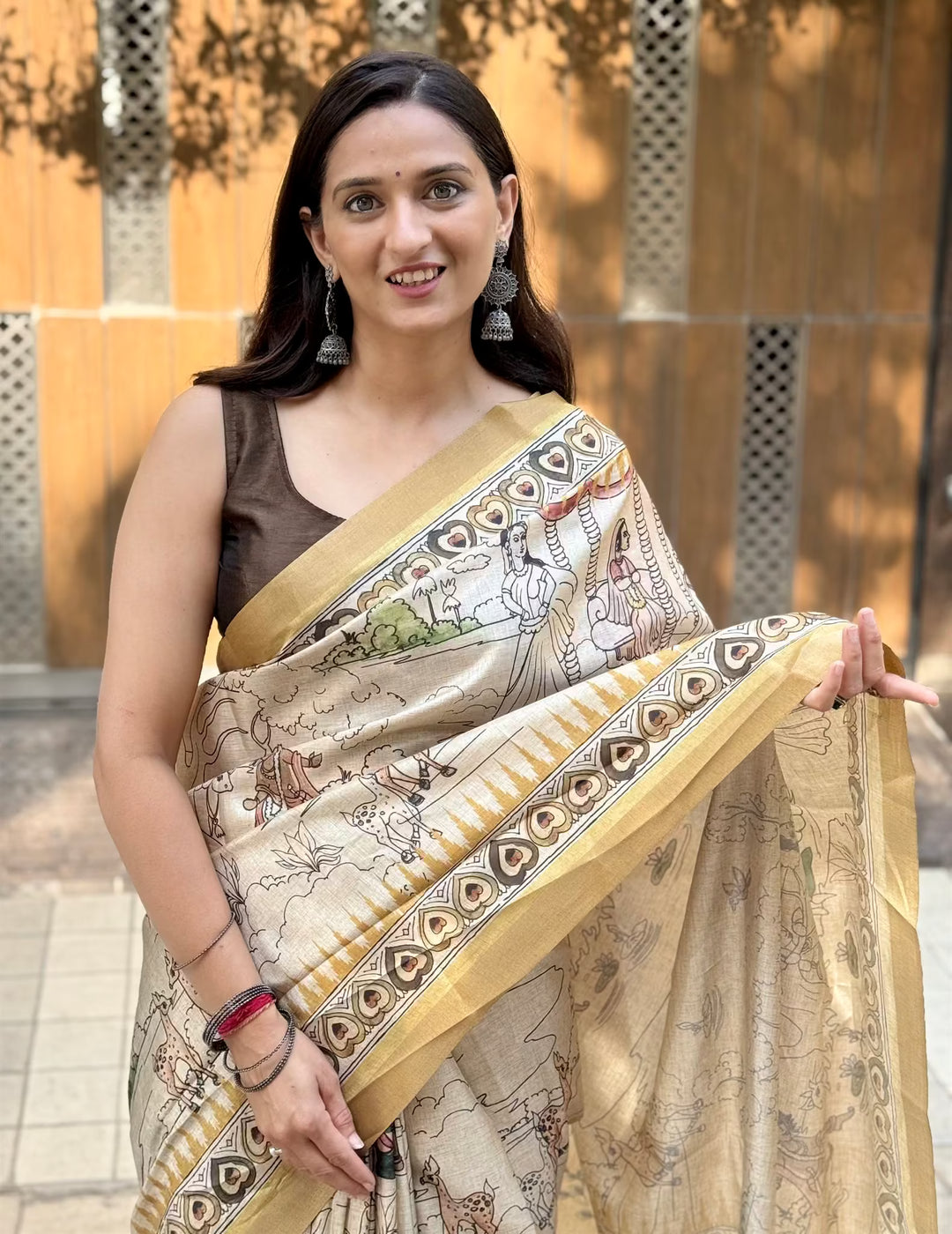Woman wearing a Cream Pen Kalamkari print saree.
