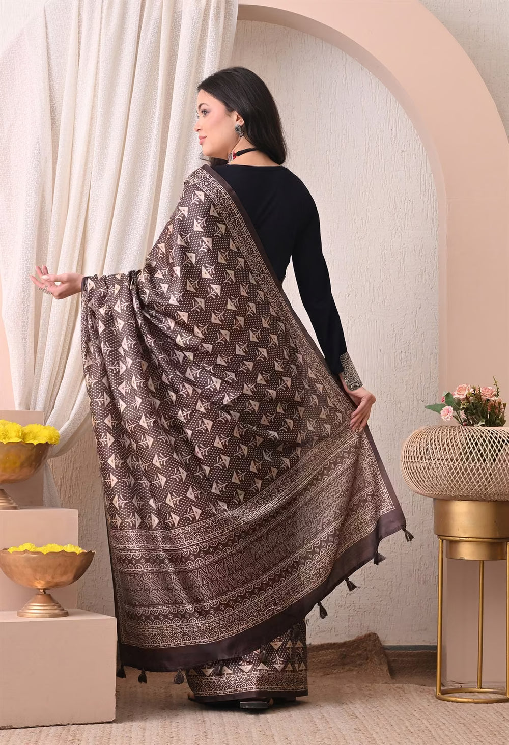 Woman in Dark Brown Ajrakh Butti print saree.