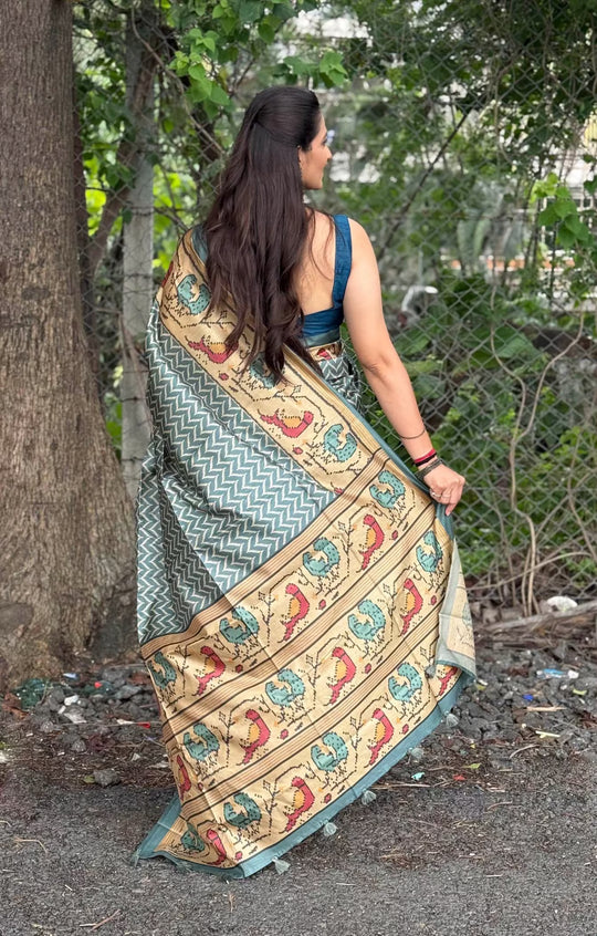 Woman in Teal Blue with Biege color border in chevron print with kalamkari bird pallu.
