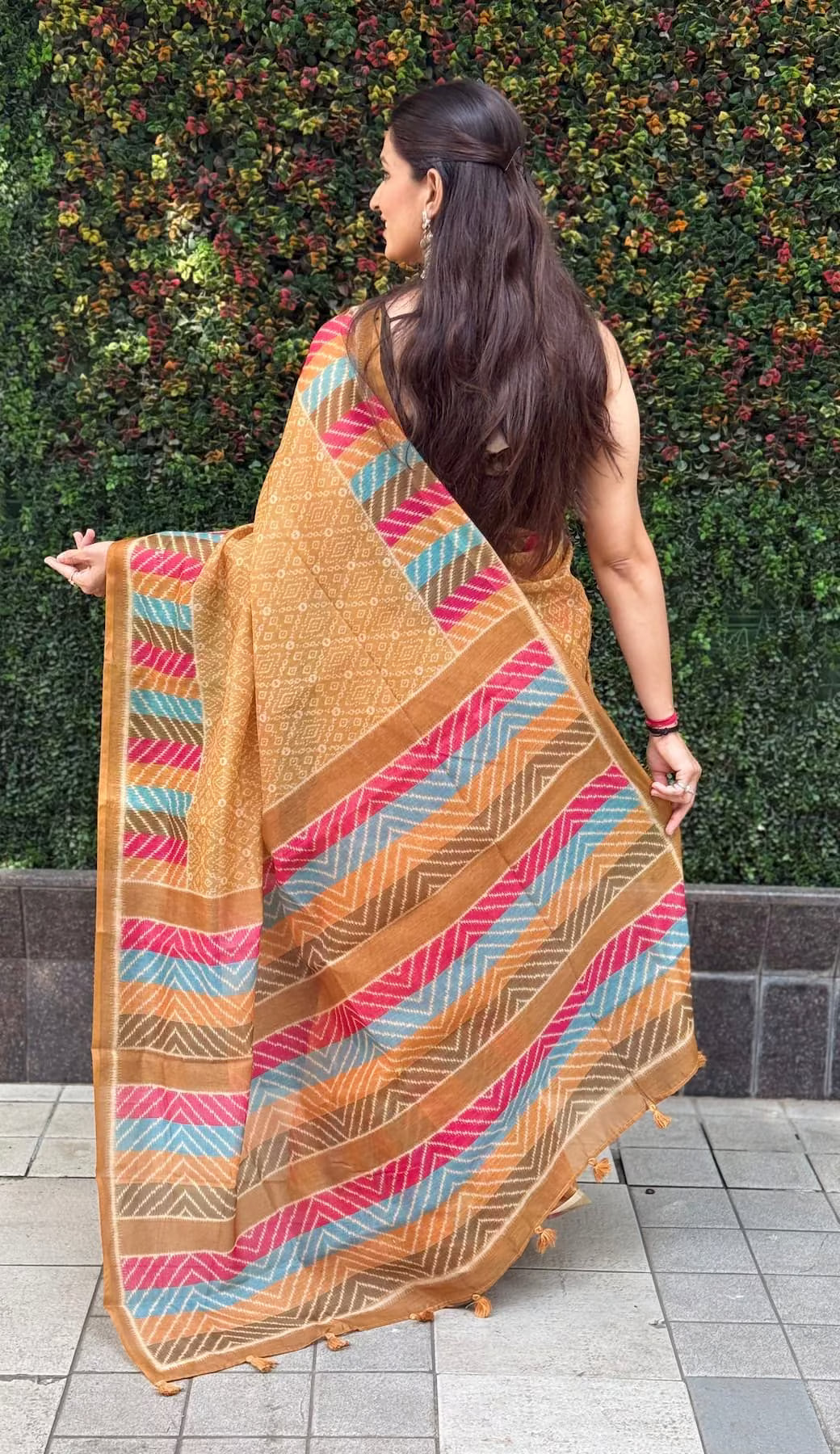 Woman wearing Mustard Bandhani Print & Multicolor Chevron Pallu Saree.
