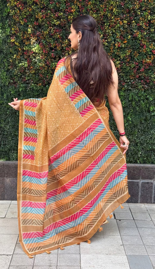 Woman wearing Mustard Bandhani Print & Multicolor Chevron Pallu Saree.
