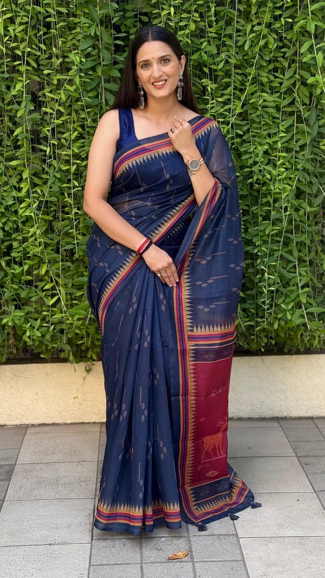 Woman in chanderi silk navy blue saree with wildlife print maroon pallu