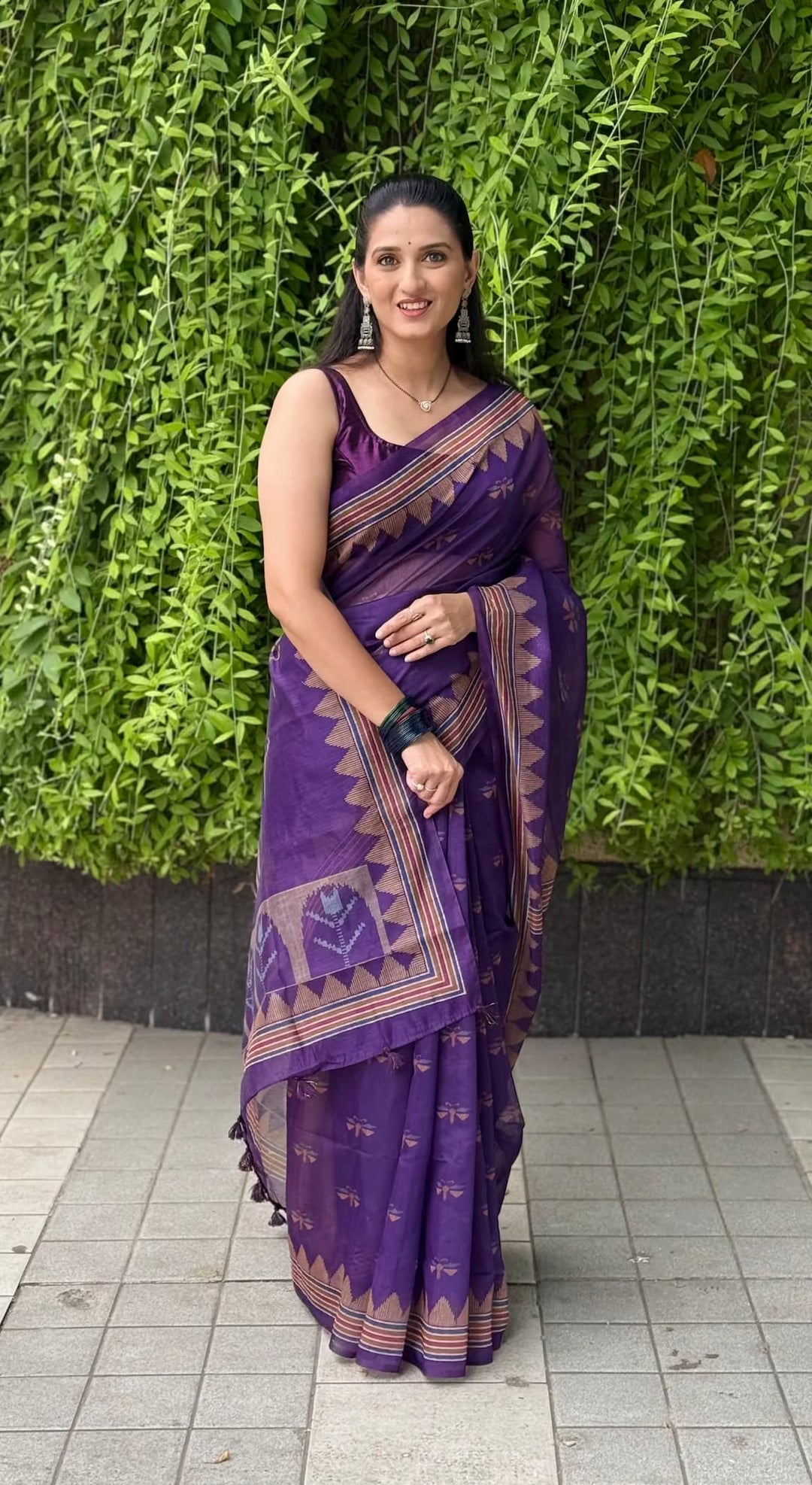 Woman in purple chanderi silk with geometric print and temple border saree.