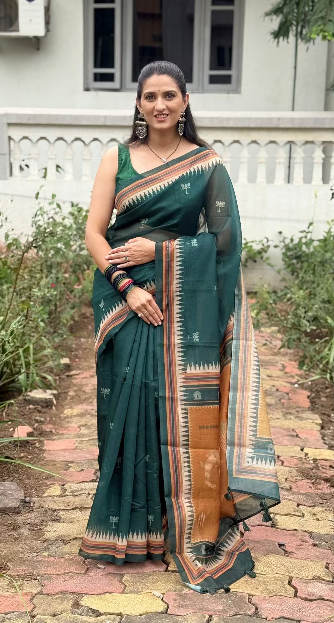 Woman wearing geometric lotus butti print with temple border saree 