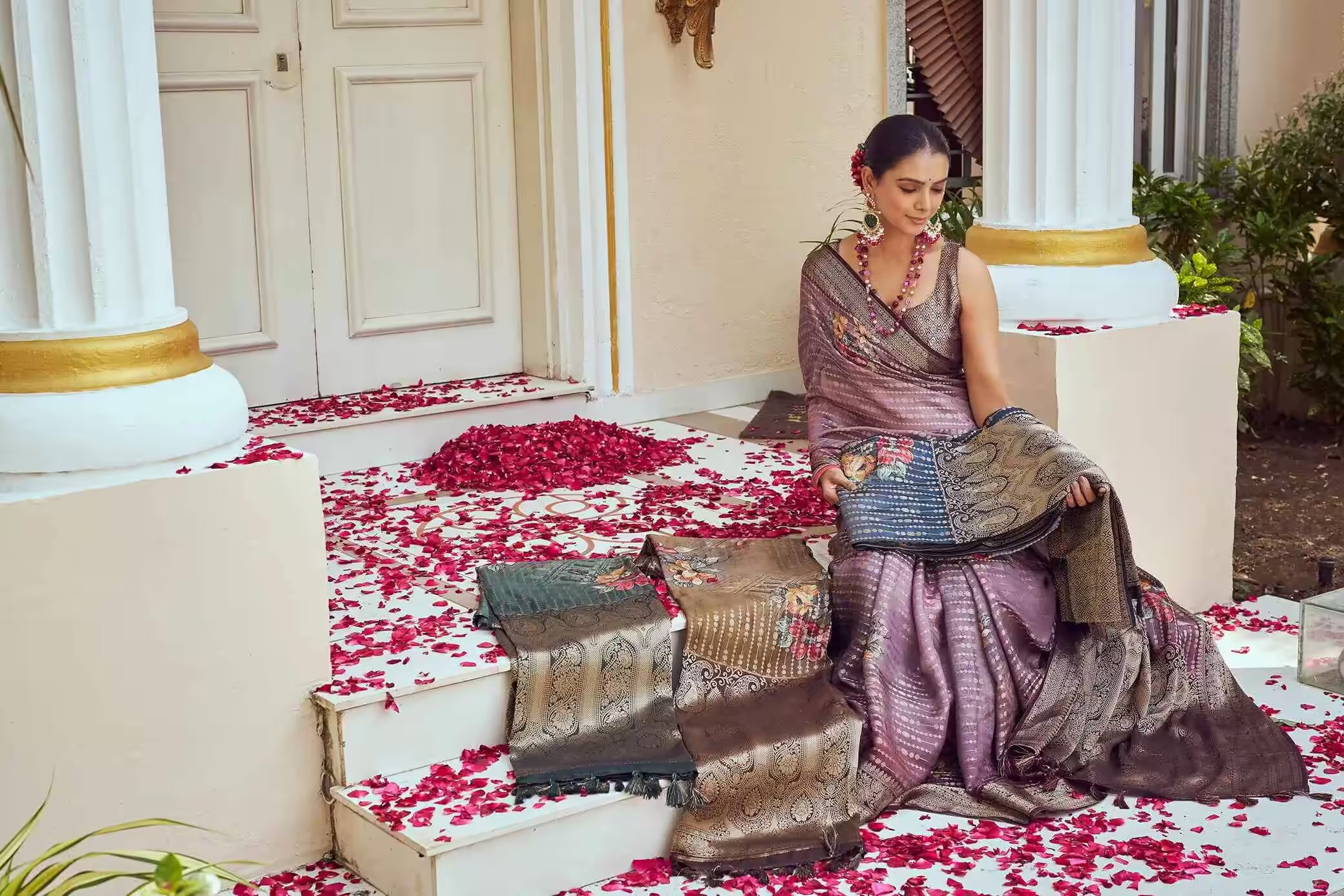 Woman in Ethnic saree sitting on steps.