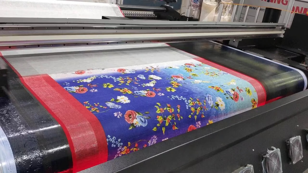 Roll of fabric with floral pattern being printed on a large printing machine.